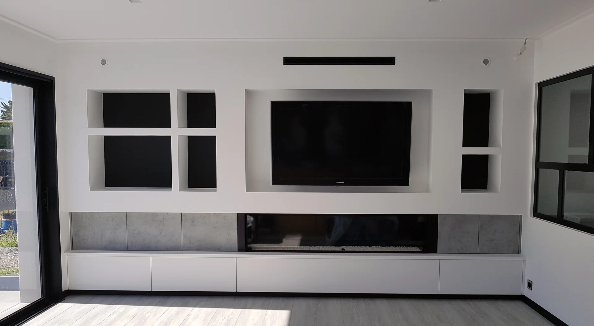 Meuble TV mural contemporain avec niches encastrées et cheminée intégrée